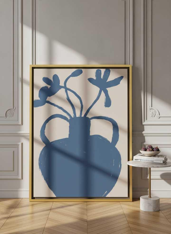 Oversized statement canvas wall art with a gold leaf surround leaning against the wall in a Parisian living room