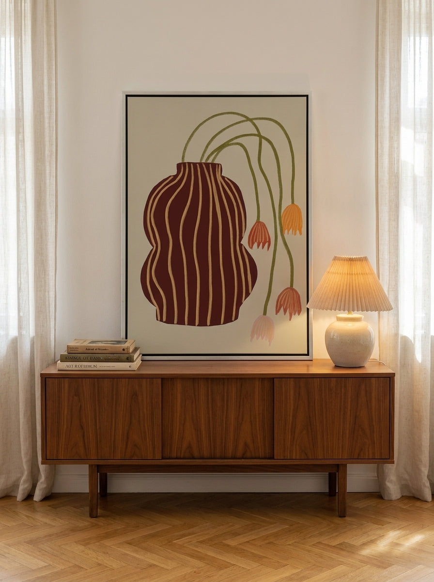Canvas wall art with a silver leaf surround standing on a sideboard in a mid-century dining room