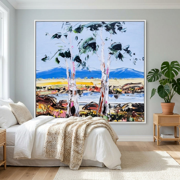 Canvas wall art with a white surround styled on the wall in a bright Scandinavian bedroom