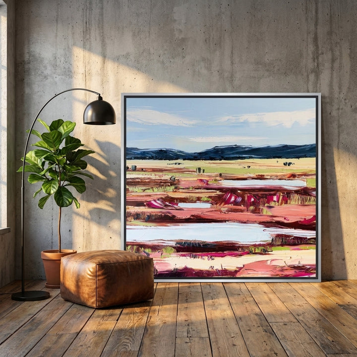 Canvas wall art with a silver leaf surround leaning against the wall in an industrial loft living room