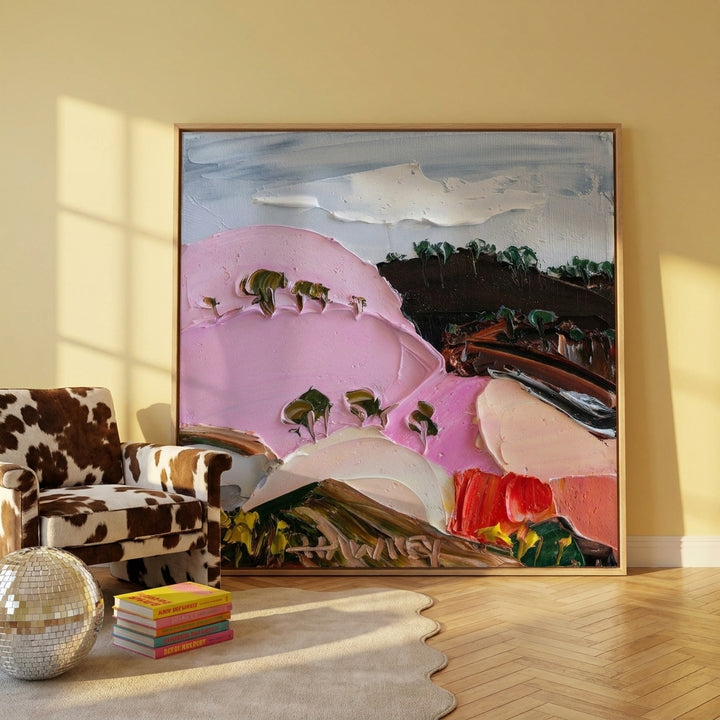 Oversized statement canvas wall art with a natural timber surround leaning against the wall in a colourful eclectic dining room