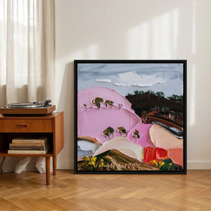 Canvas wall art with a black surround leaning against the wall in a mid-century bedroom