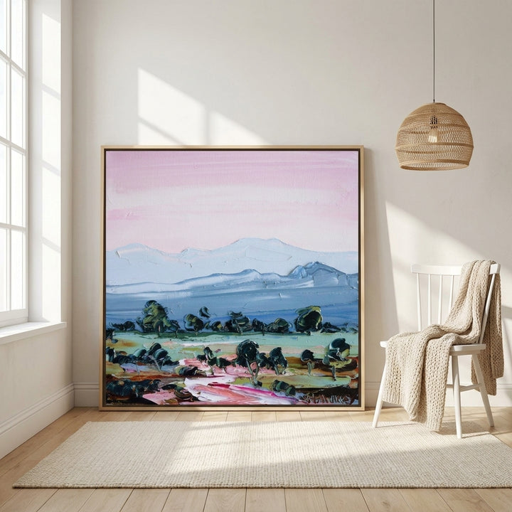Oversized statement canvas wall art with a natural timber surround leaning against the wall in a bright Scandinavian bedroom