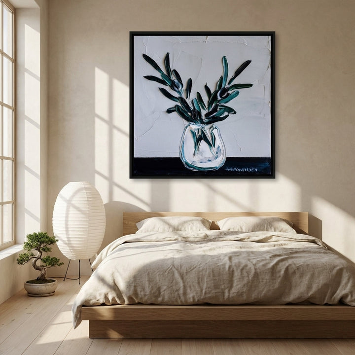 Canvas wall art with a black surround styled on the wall in a warm Japandi bedroom