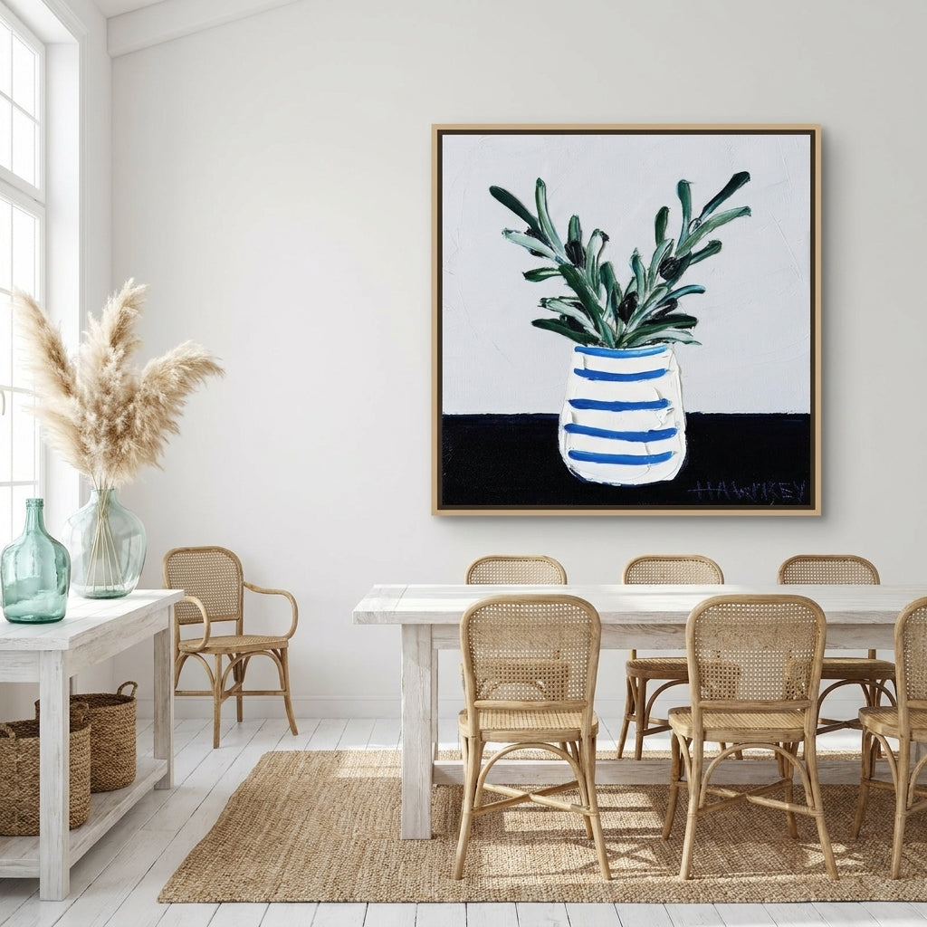 Oversized statement canvas wall art with a natural timber surround styled on the wall in a coastal dining room