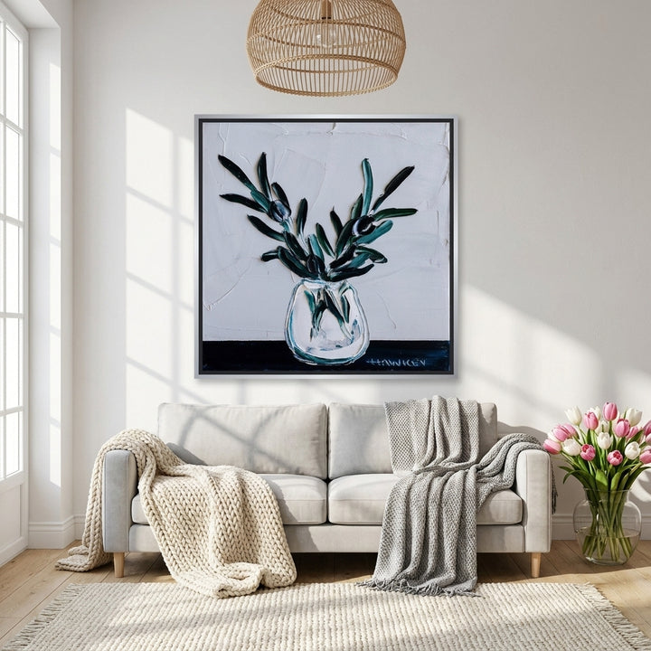 Canvas wall art with a silver leaf surround styled on the wall in a bright Scandinavian living room