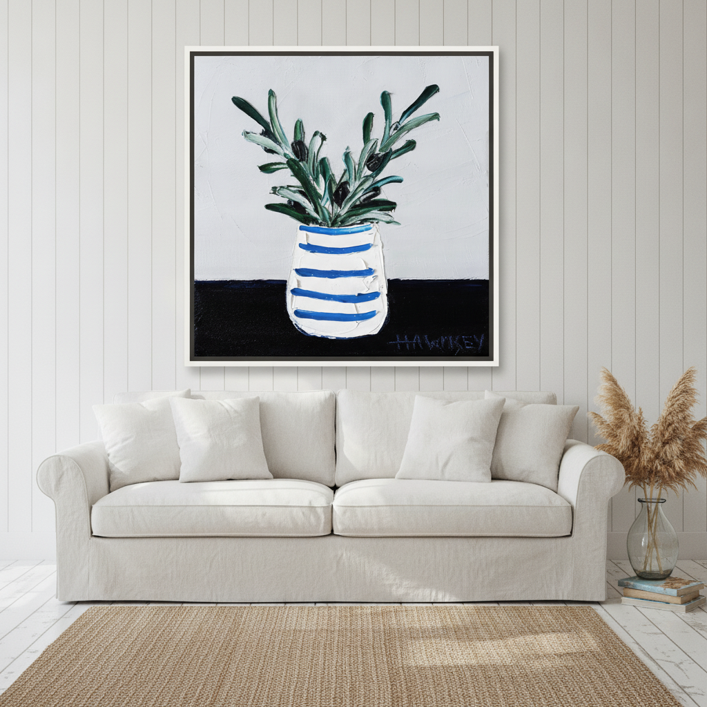 Oversized statement canvas wall art with a white surround styled on the wall in a coastal living room