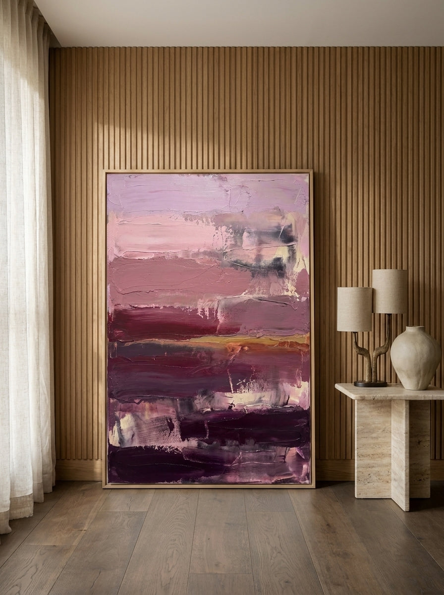 Oversized statement canvas wall art with a natural timber surround leaning against the wall in a luxe dining room