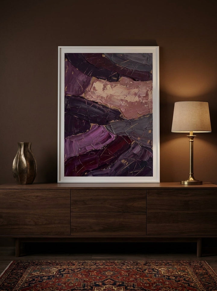 Modern wall art print standing on a sideboard in a moody home office
