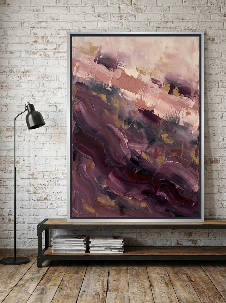 Canvas wall art with a silver leaf surround standing on a console in an industrial loft bedroom