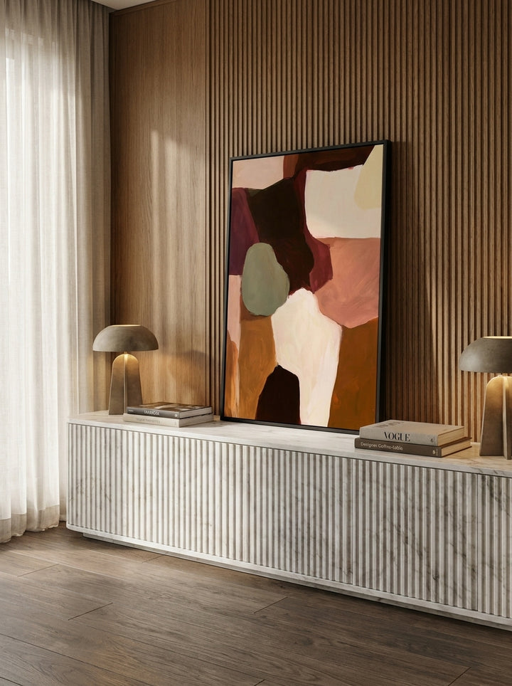 Modern wall art print standing on a sideboard in a luxe living room