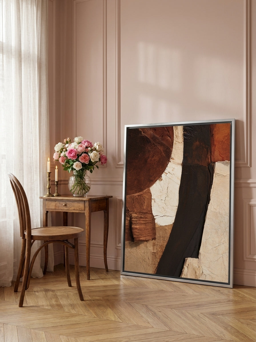 Canvas wall art with a silver leaf surround leaning against the wall in a Parisian home office