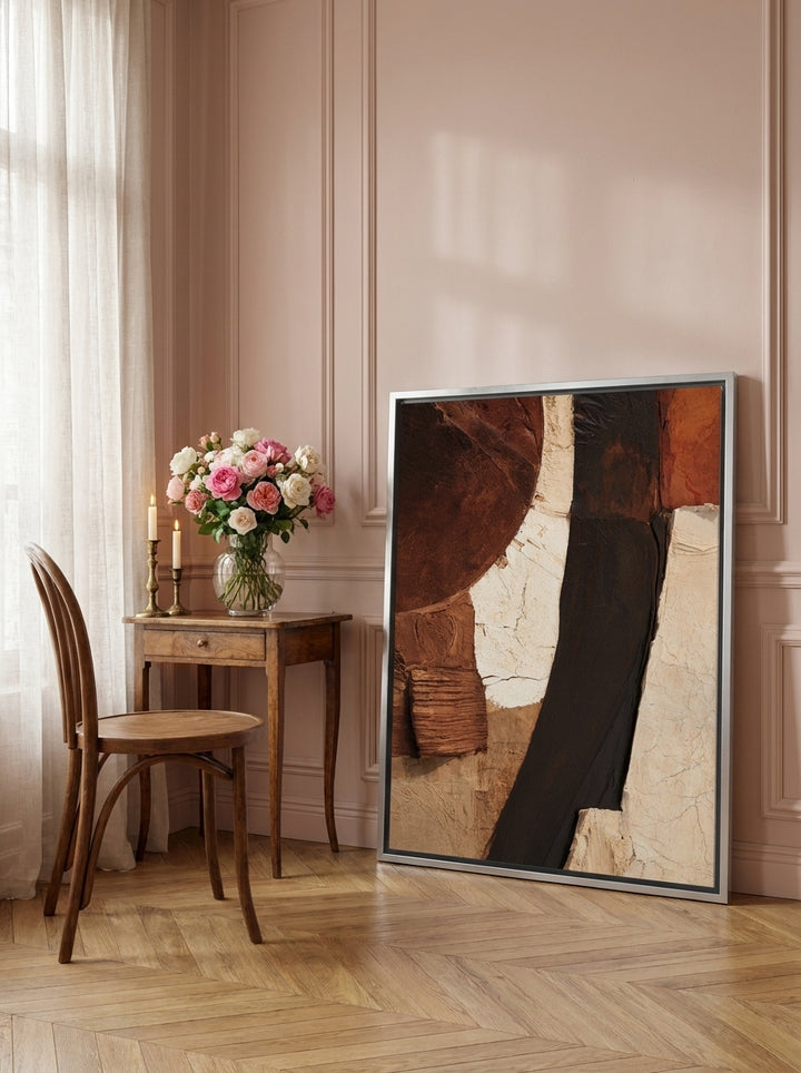 Canvas wall art with a silver leaf surround leaning against the wall in a Parisian home office