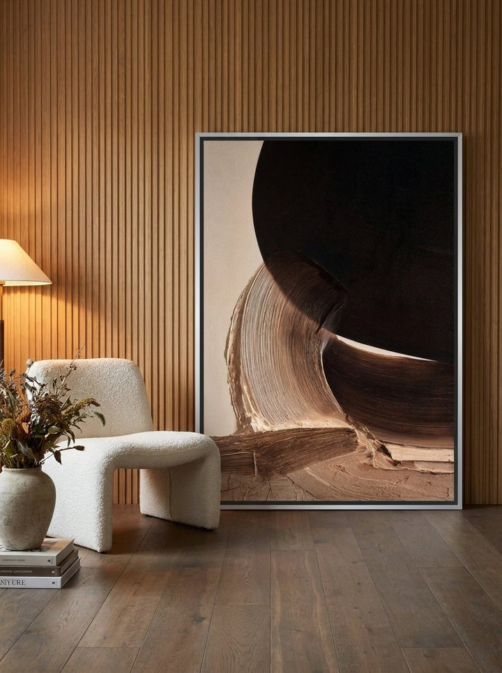 Oversized statement canvas wall art with a silver leaf surround leaning against the wall in a luxe dining room