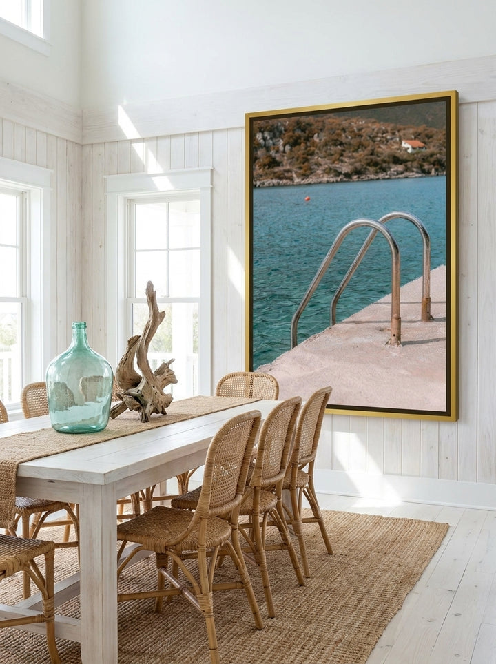 Oversized statement canvas wall art with a gold leaf surround styled on the wall in a coastal dining room