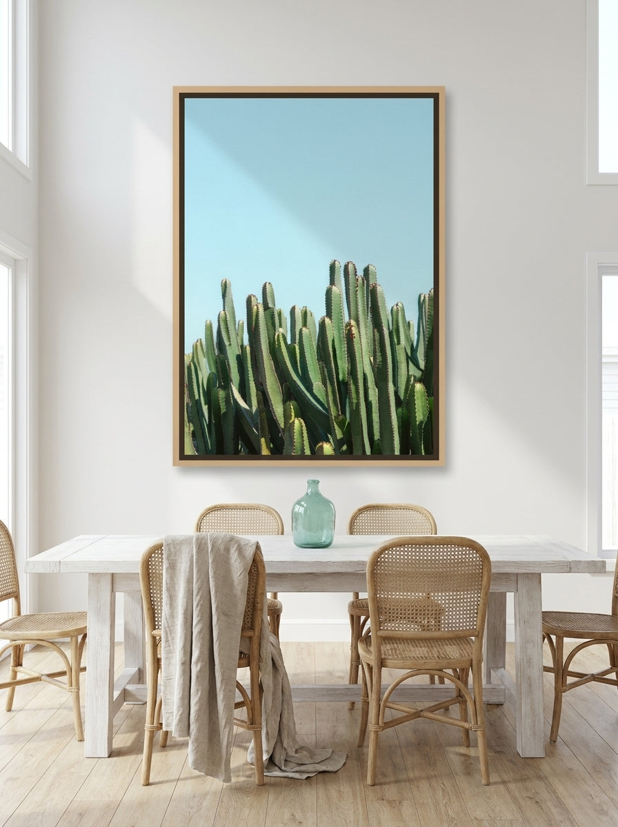 Oversized statement canvas wall art with a natural timber surround styled on the wall in a coastal dining room