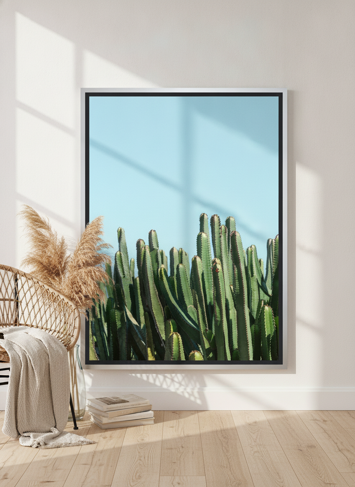 Oversized statement canvas wall art with a silver leaf surround leaning against the wall in a coastal bedroom