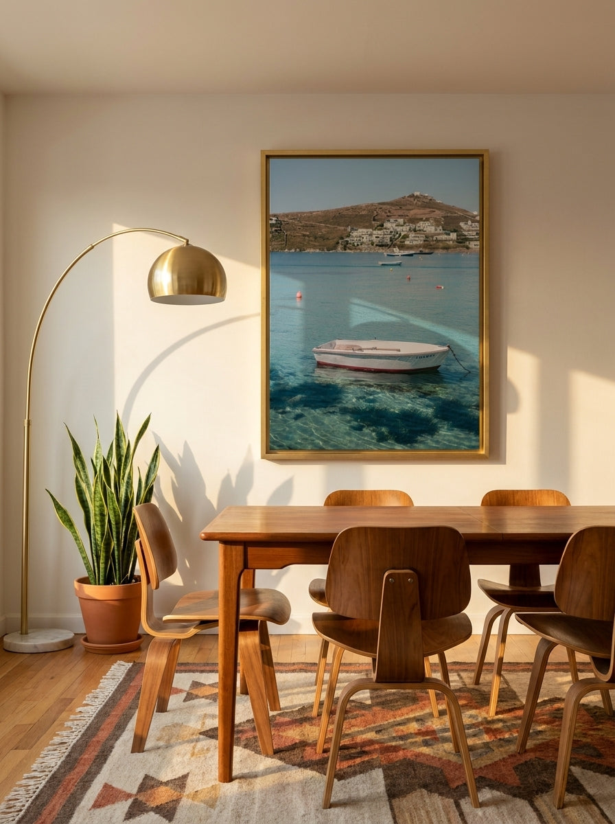 Oversized statement canvas wall art with a gold leaf surround styled on the wall in a mid-century dining room