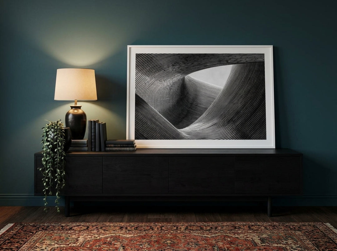 Modern wall art print standing on a console in a moody living room