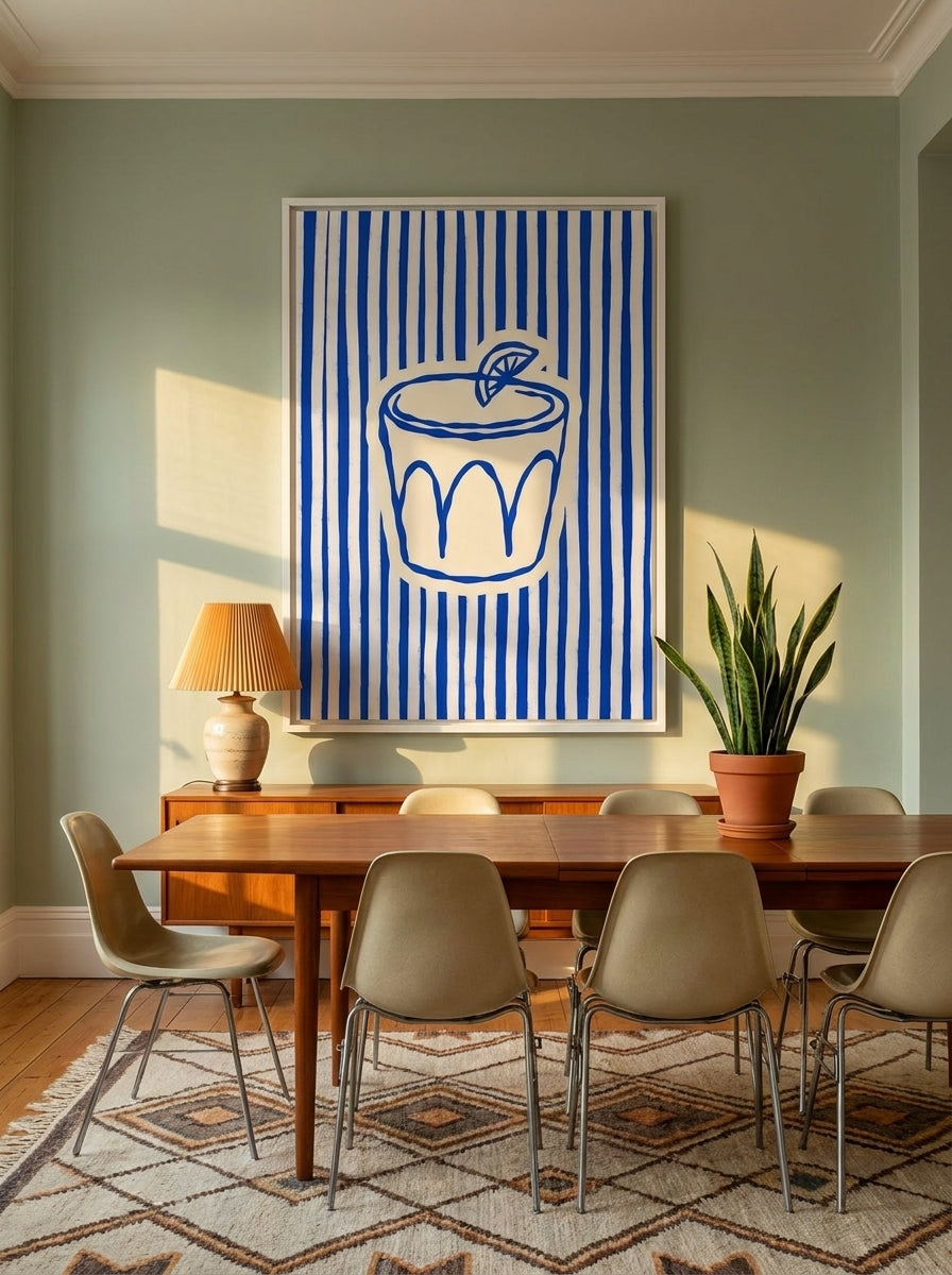 Oversized statement canvas wall art with a white surround styled on the wall in a mid-century dining room