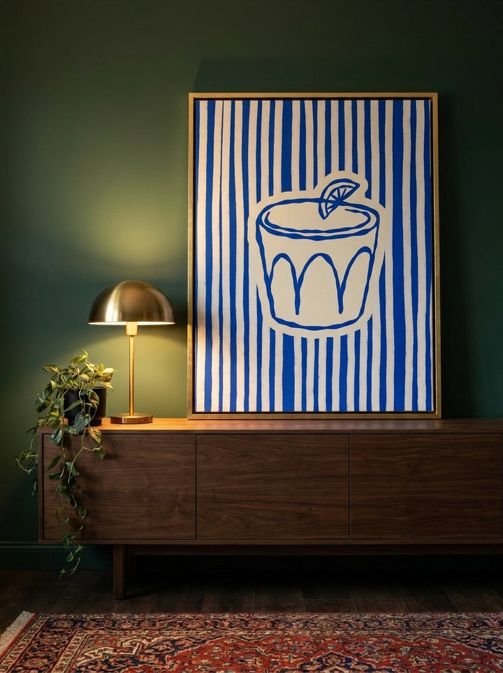 Canvas wall art with a gold leaf surround standing on a sideboard in a moody living room