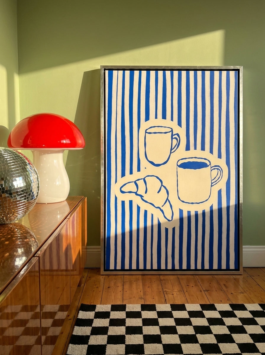 Canvas wall art with a silver leaf surround standing on a sideboard in a colourful eclectic dining room