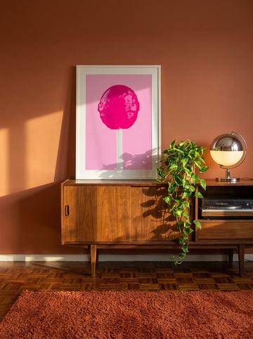 Modern wall art print standing on a sideboard in a retro 70s bedroom