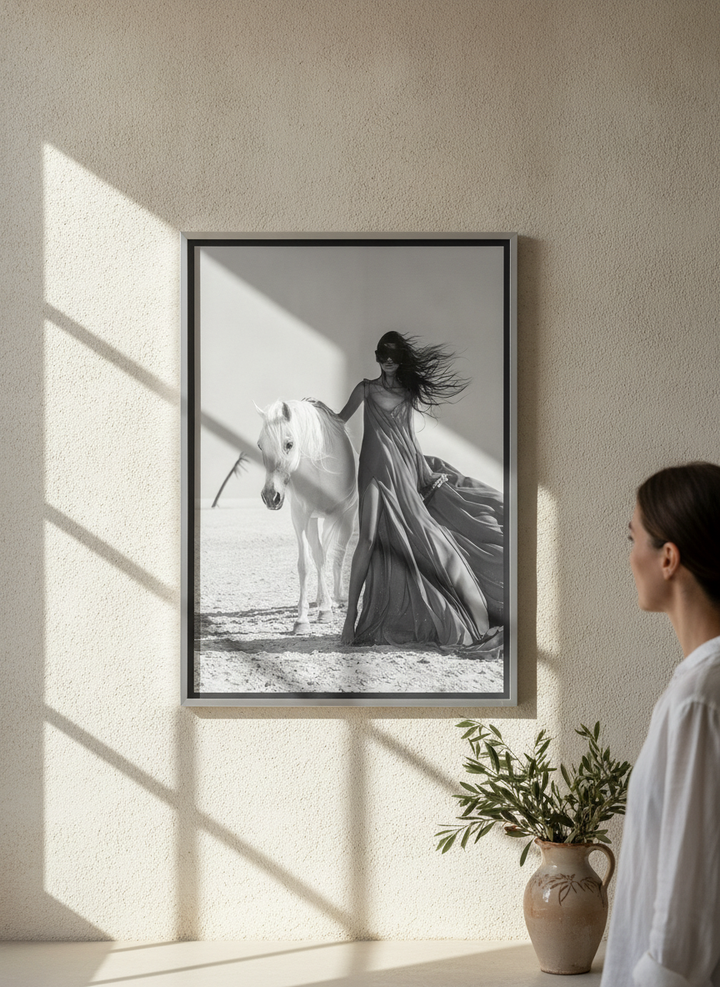 Person holding canvas wall art with a silver leaf surround in a Mediterranean living room