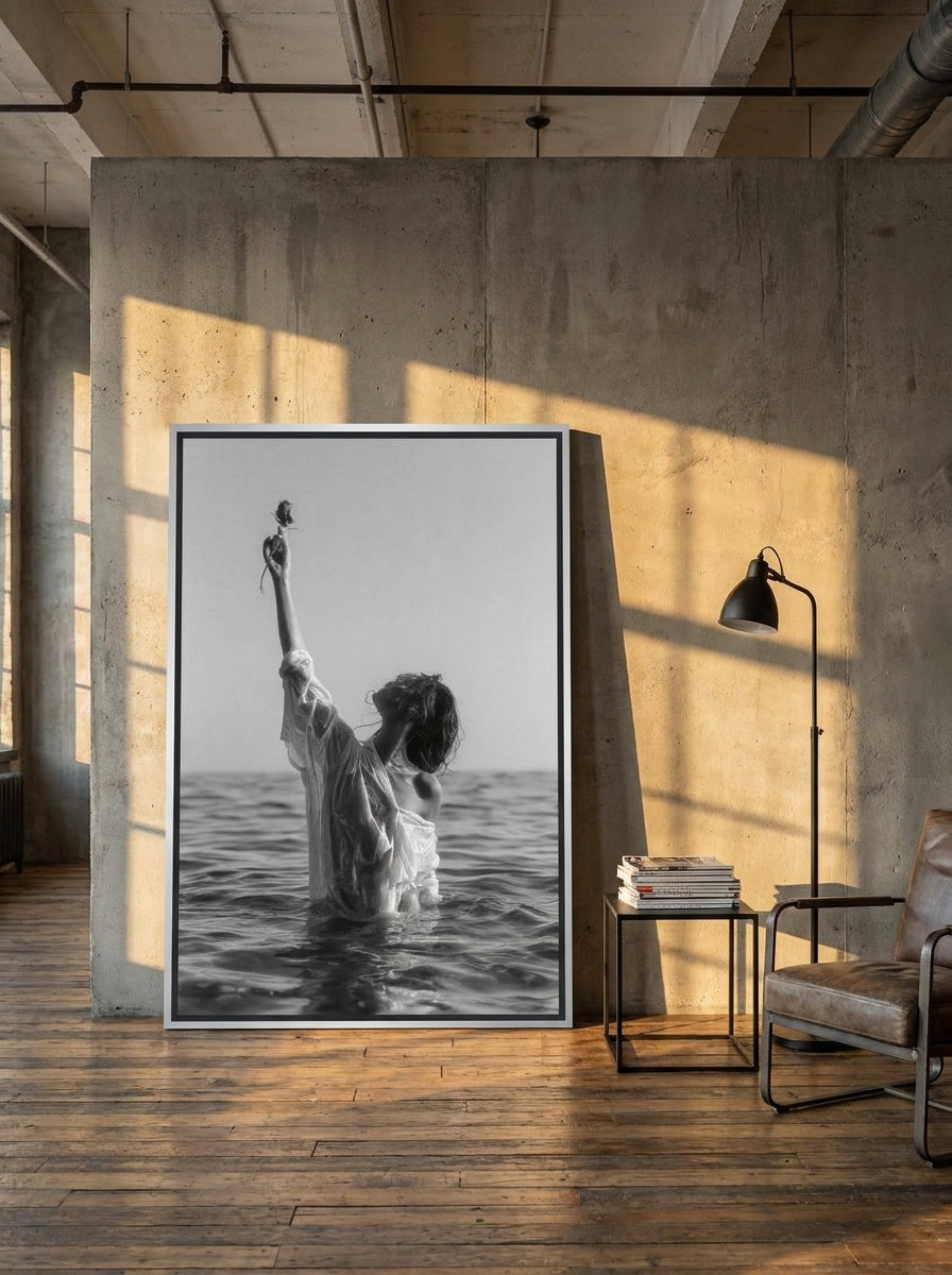 Oversized statement canvas wall art with a silver leaf surround leaning against the wall in an industrial loft living room