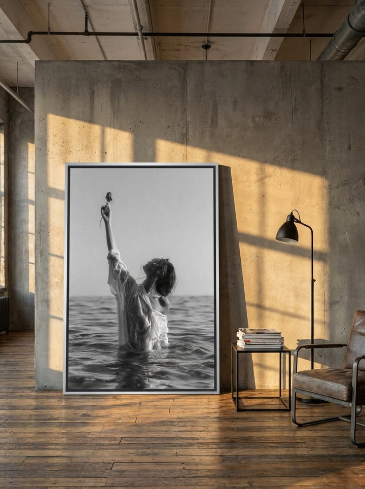 Oversized statement canvas wall art with a silver leaf surround leaning against the wall in an industrial loft living room