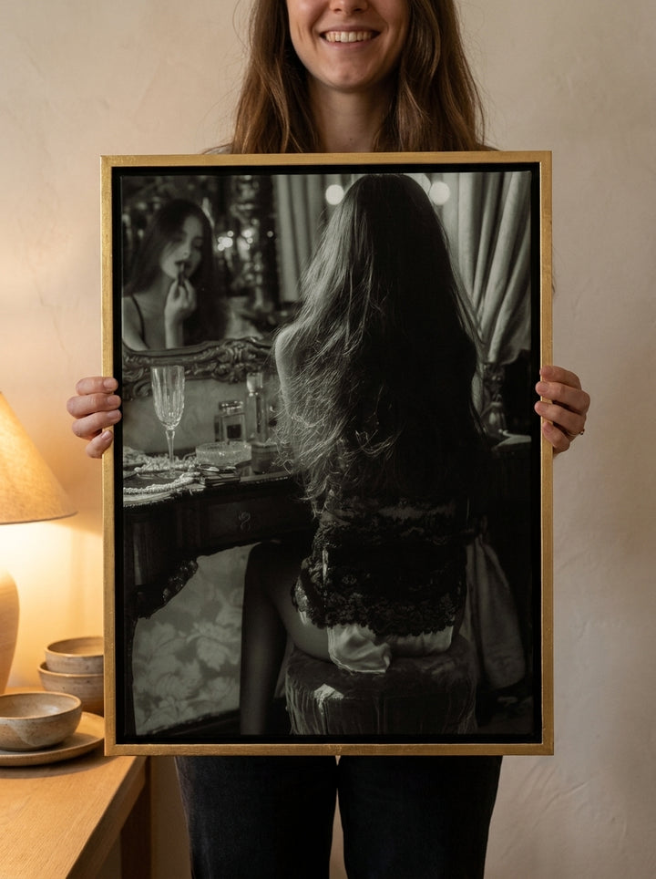 Person holding canvas wall art with a gold leaf surround in a warm Japandi living room