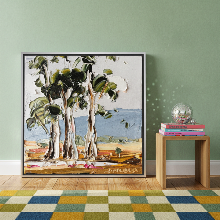 Canvas wall art with a silver leaf surround standing on a side table in a colourful eclectic living room