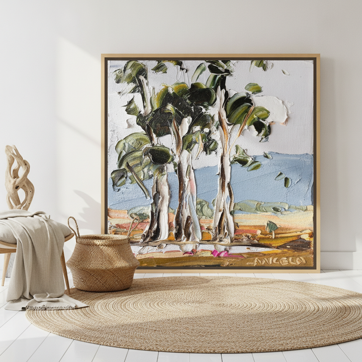 Oversized statement canvas wall art with a natural timber surround leaning against the wall in a coastal dining room