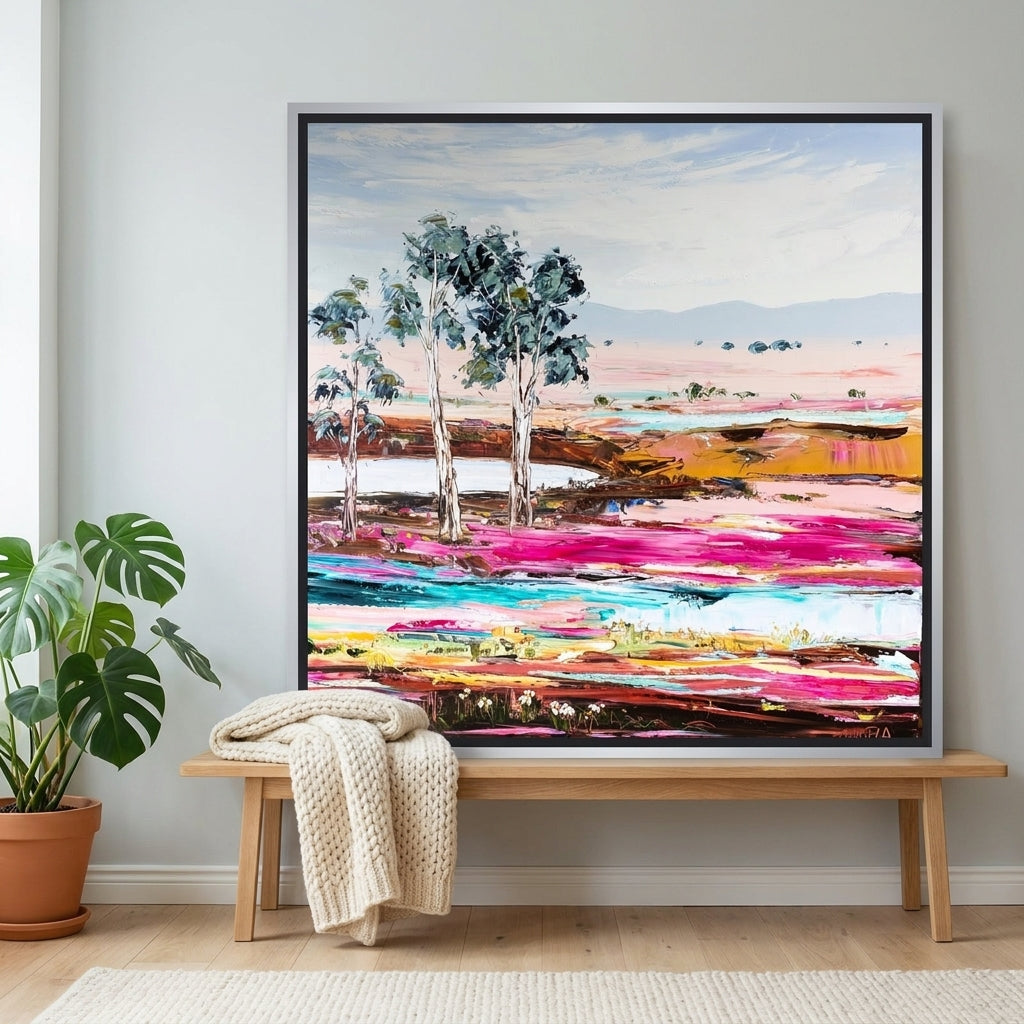 Canvas wall art with a silver leaf surround standing on a bench in a bright Scandinavian living room