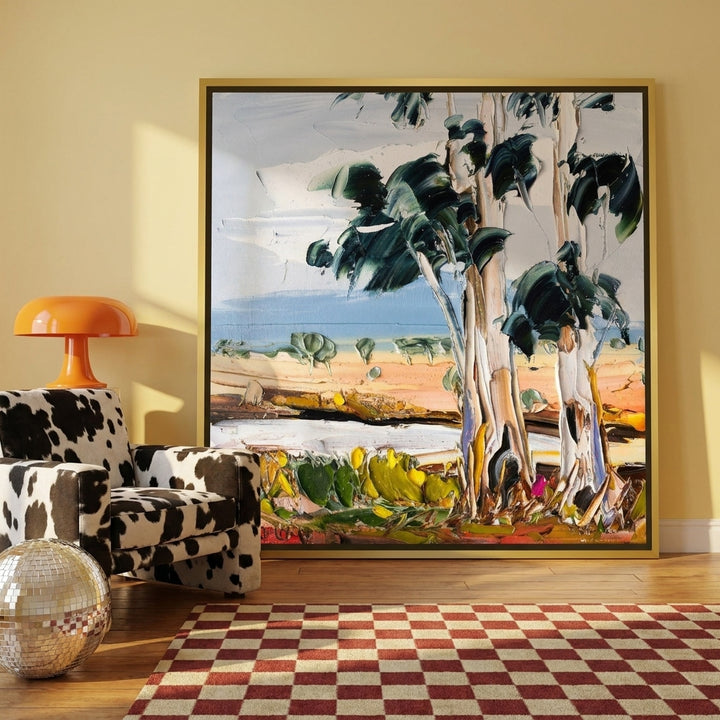 Oversized statement canvas wall art with a gold leaf surround leaning against the wall in a colourful eclectic living room