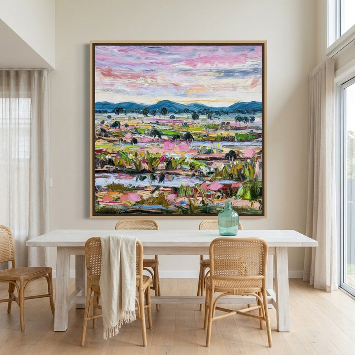 Oversized statement canvas wall art with a natural timber surround styled on the wall in a coastal dining room
