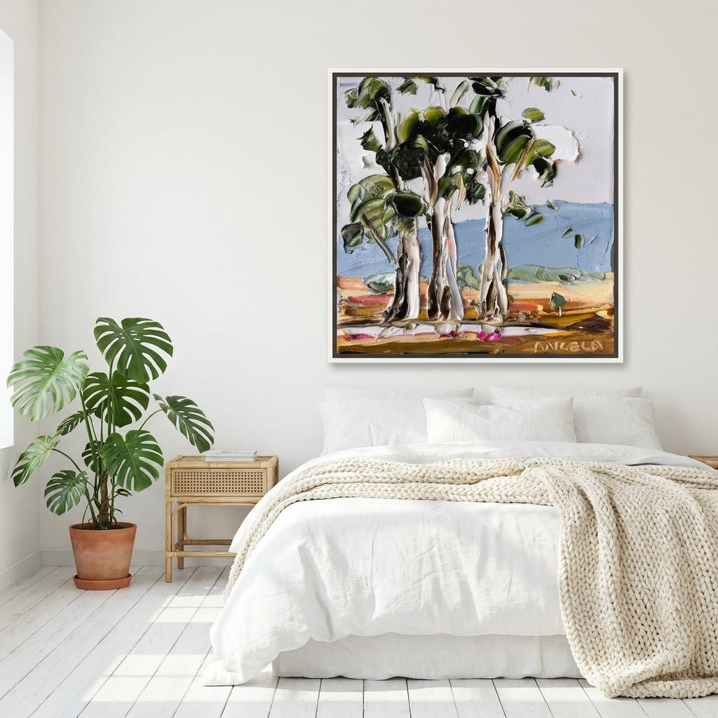 Canvas wall art with a white surround styled on the wall in a bright Scandinavian bedroom