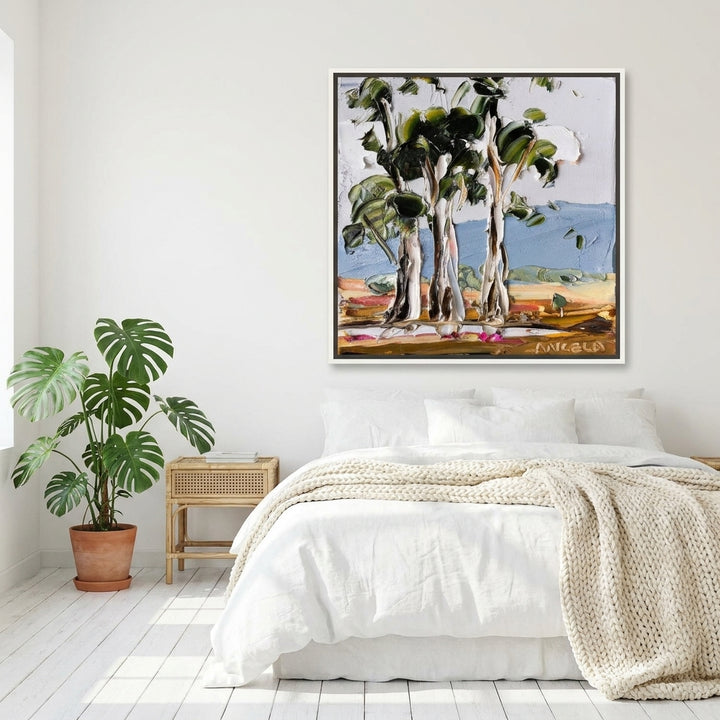 Canvas wall art with a white surround styled on the wall in a bright Scandinavian bedroom
