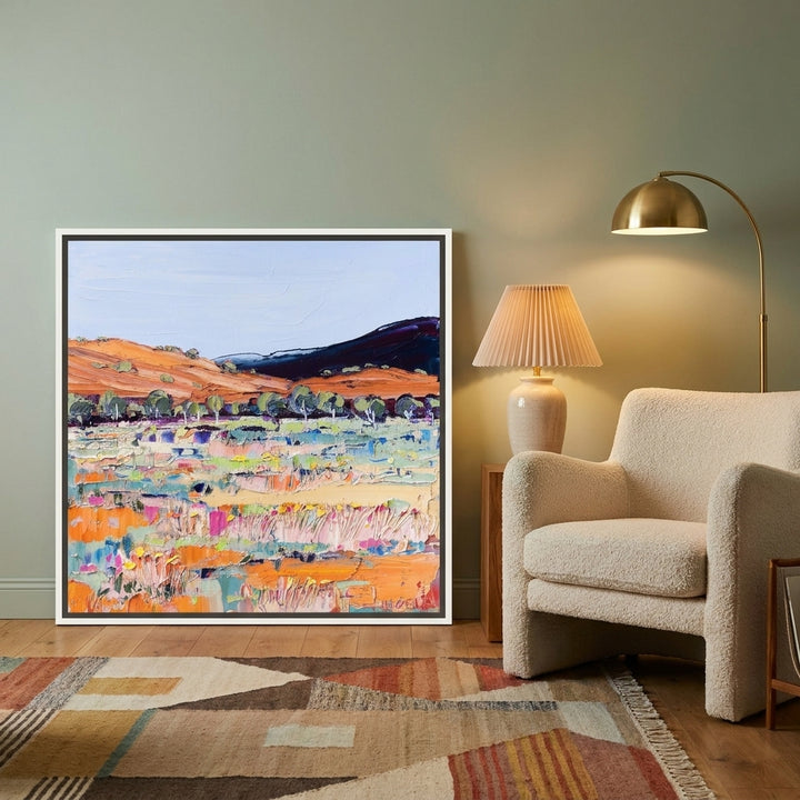 Canvas wall art with a white surround leaning against the wall in a mid-century home office