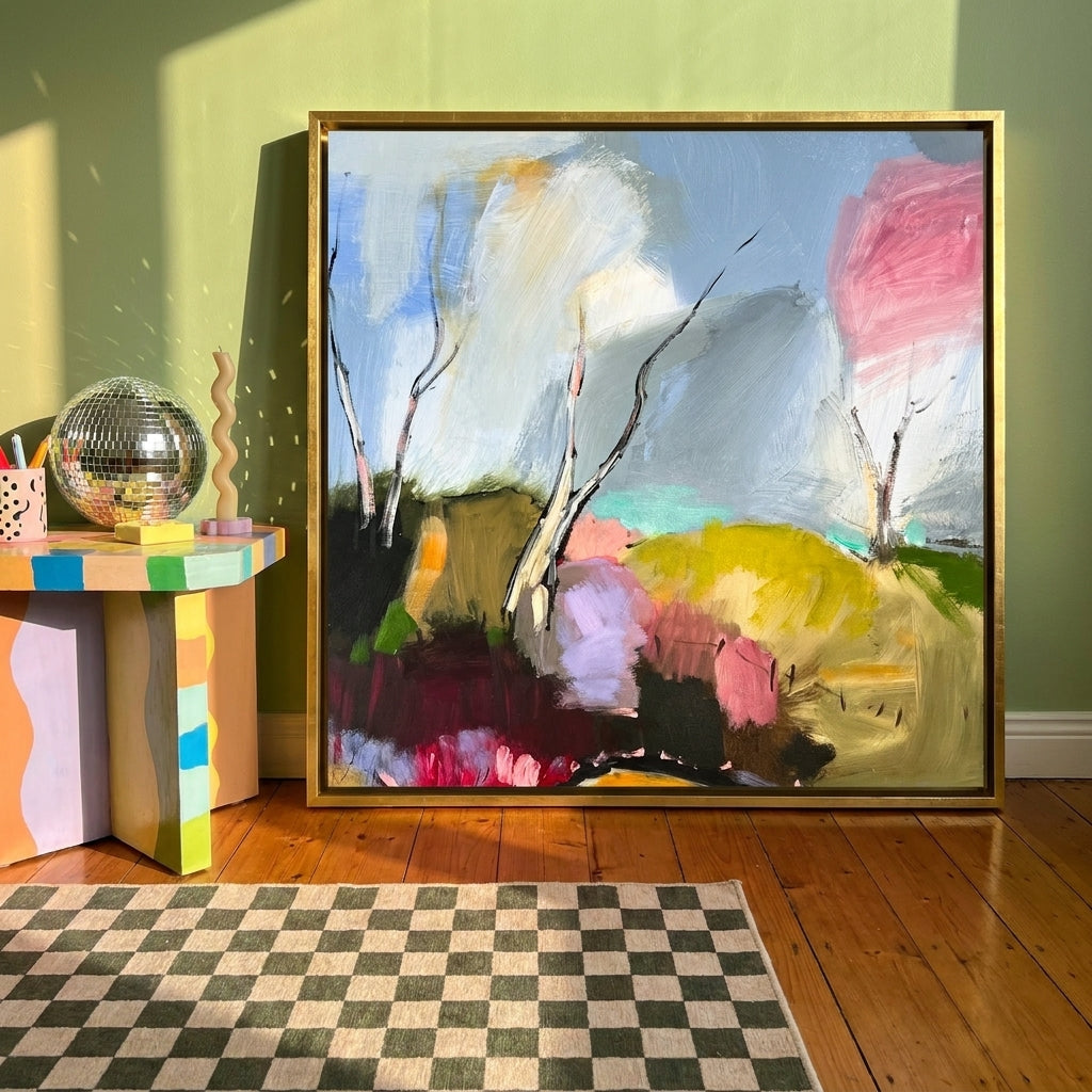 Canvas wall art with a gold leaf surround standing on a side table in a colourful eclectic home office