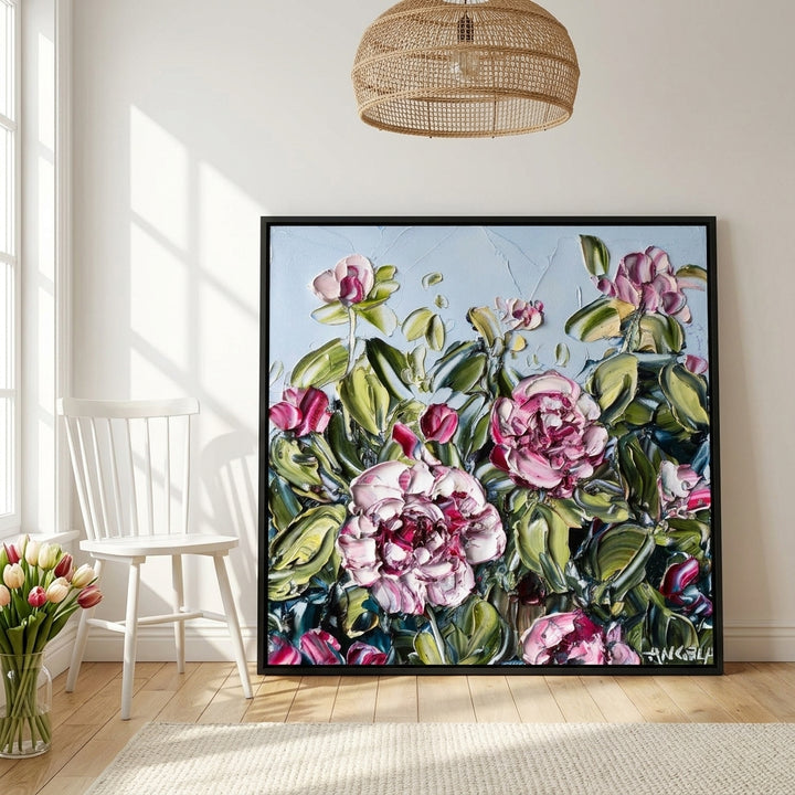 Oversized statement canvas wall art with a black surround leaning against the wall in a bright Scandinavian dining room