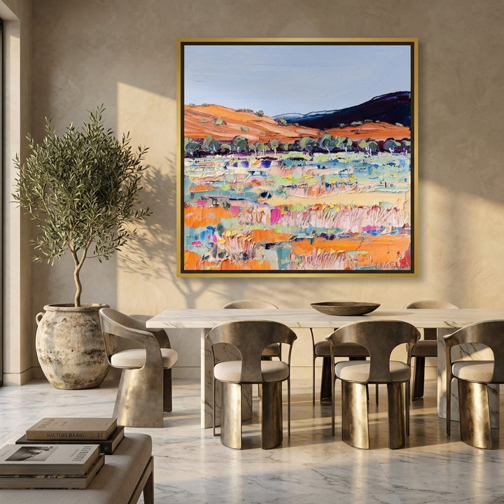 Oversized statement canvas wall art with a gold leaf surround styled on the wall in a luxe dining room