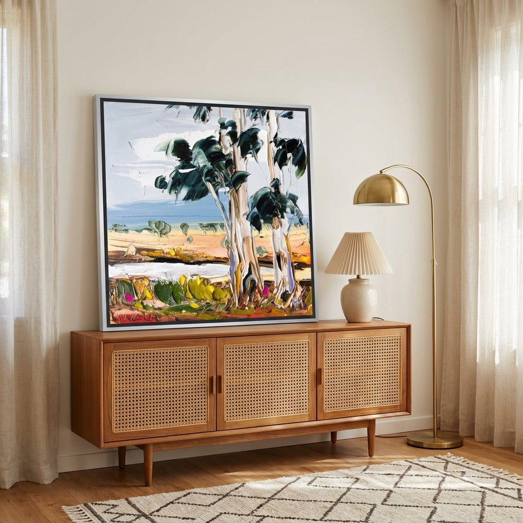Canvas wall art with a silver leaf surround standing on a sideboard in a mid-century home office