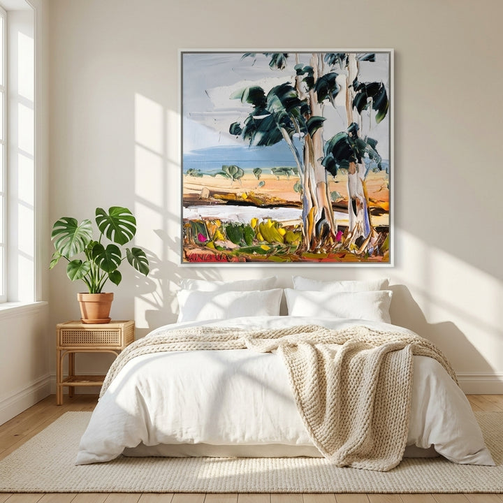 Canvas wall art with a white surround styled on the wall in a bright Scandinavian bedroom