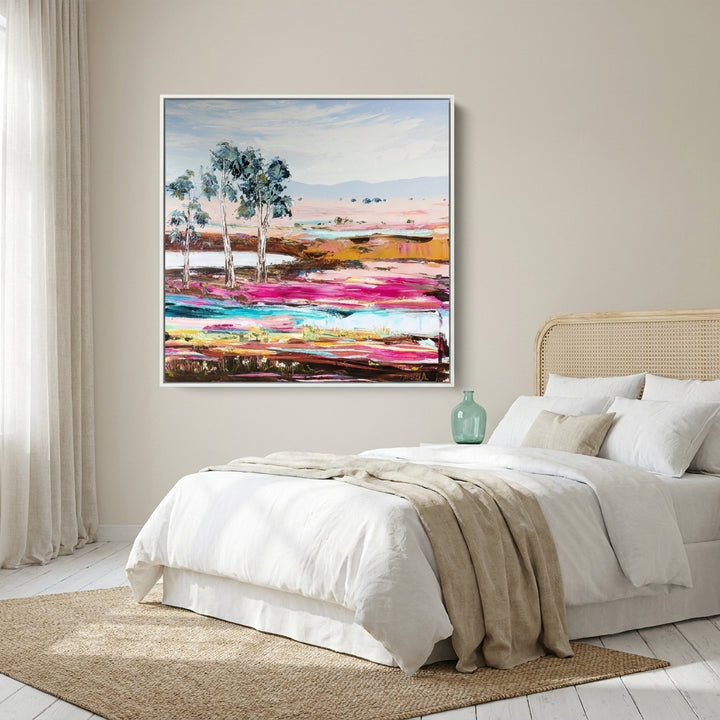 Canvas wall art with a white surround styled on the wall in a coastal bedroom