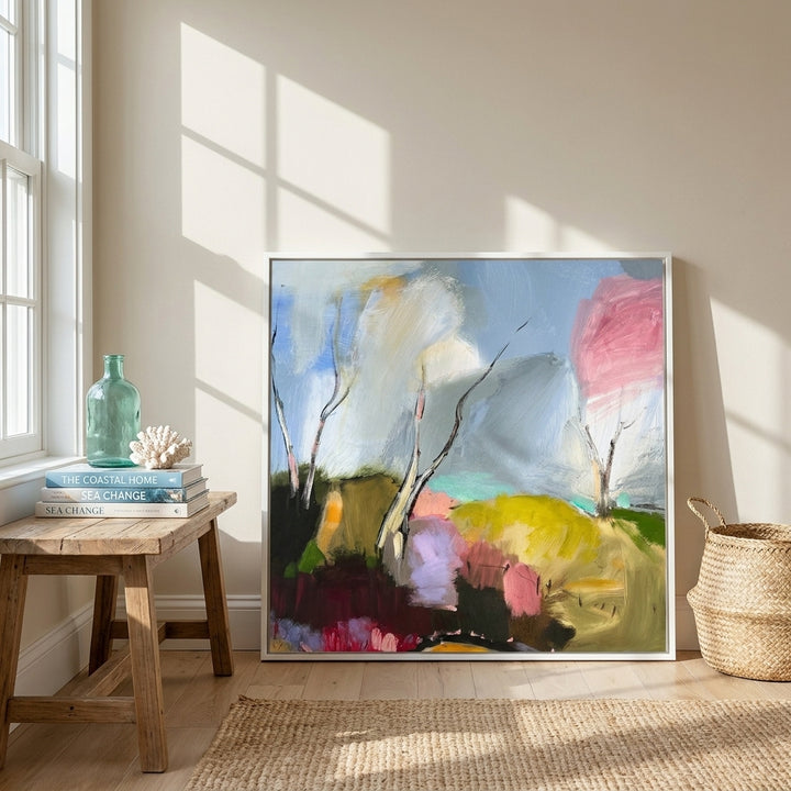 Canvas wall art with a white surround leaning against the wall in a coastal dining room