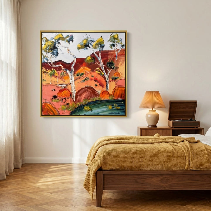 Canvas wall art with a gold leaf surround styled on the wall in a mid-century bedroom