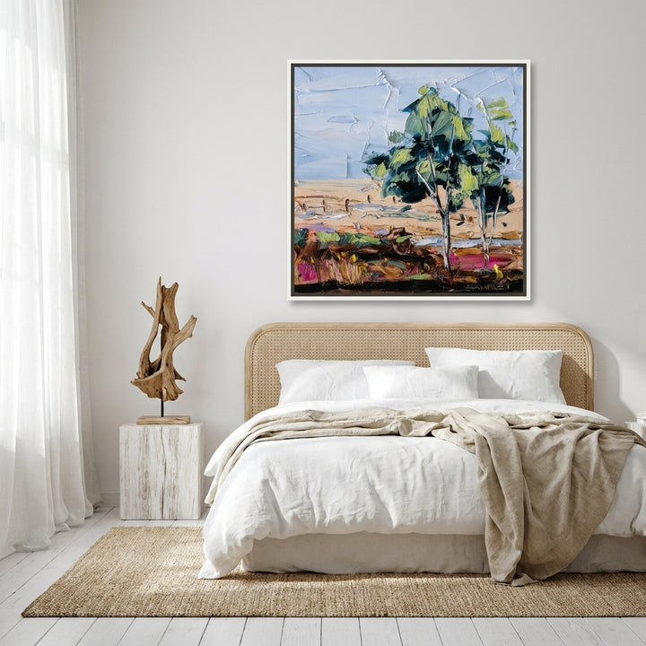 Canvas wall art with a white surround styled on the wall in a coastal bedroom