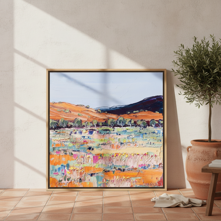 Oversized statement canvas wall art with a natural timber surround leaning against the wall in a Mediterranean dining room