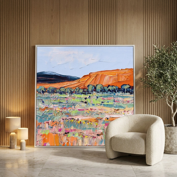 Oversized statement canvas wall art with a white surround leaning against the wall in a luxe bedroom